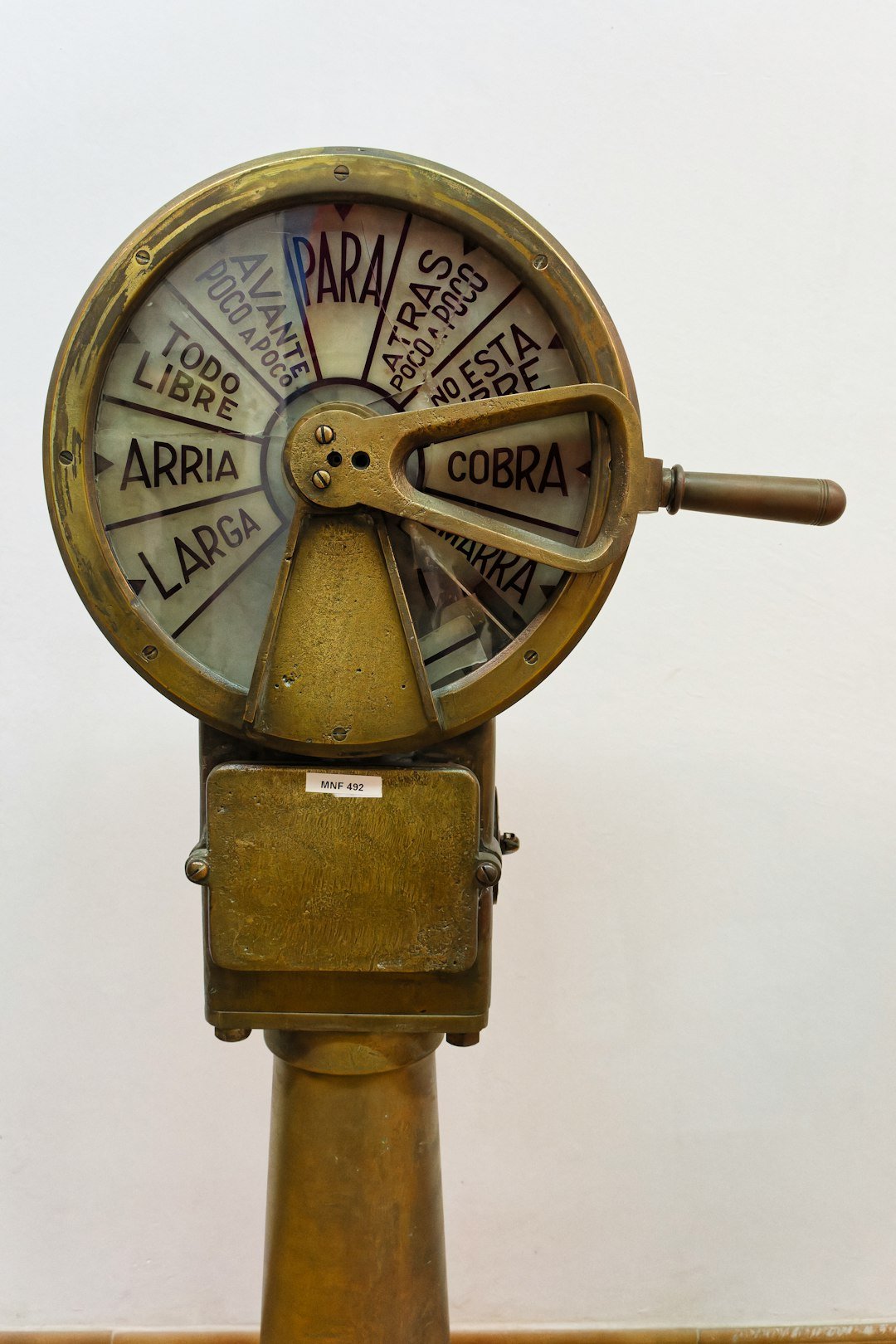 Vintage brass ships engine order telegraph in a maritime museum - A brass ships engine order telegraph with dials indicating commands, displayed in a maritime museum for educational purposes.