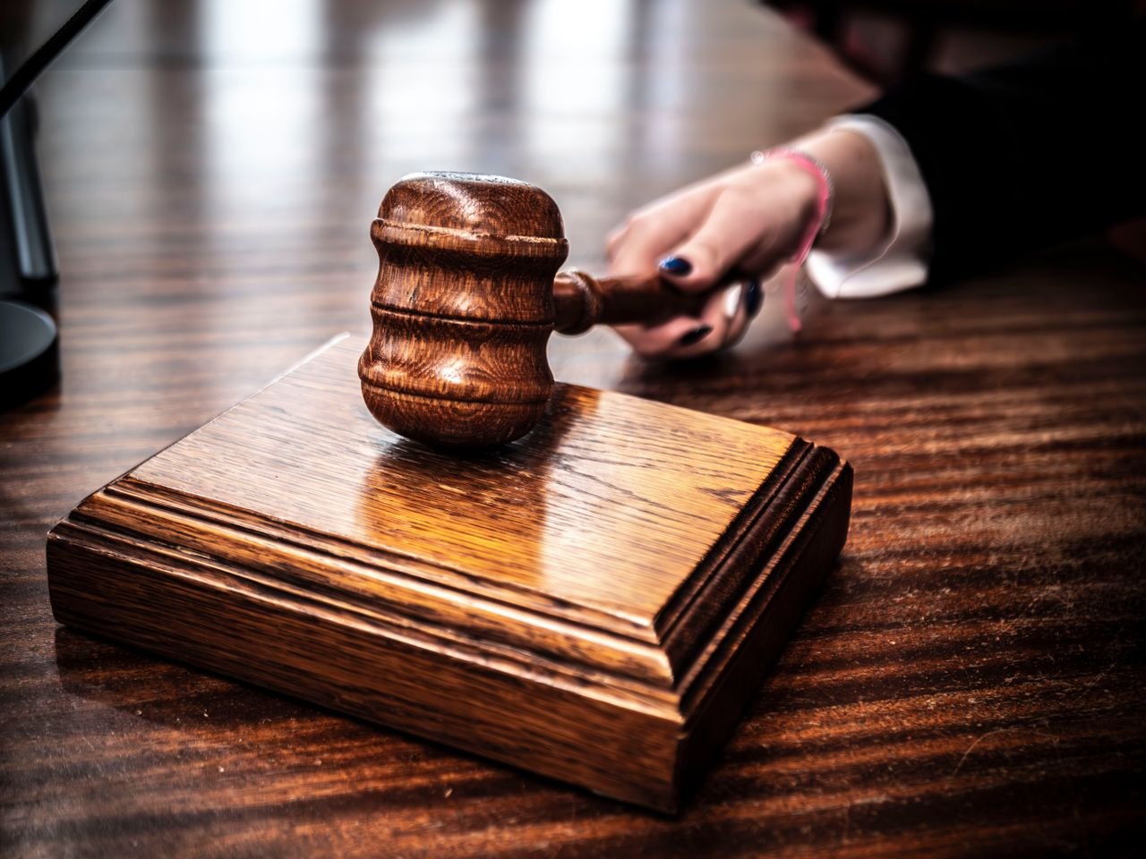 gallery-05 Close-up of a wooden gavel on a judges desk, symbolizing justice.