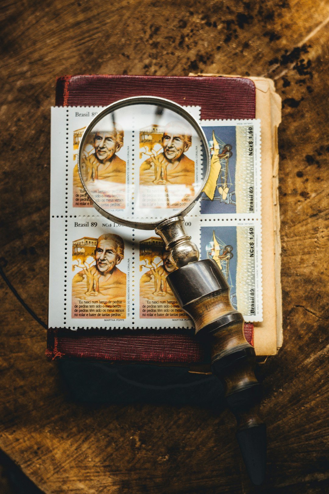 classes-04 Magnifying glass with old vintage book and brazilian stamps.